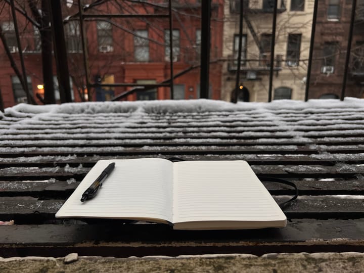 A blank notebook on a fire escape. Fresh snow in background.